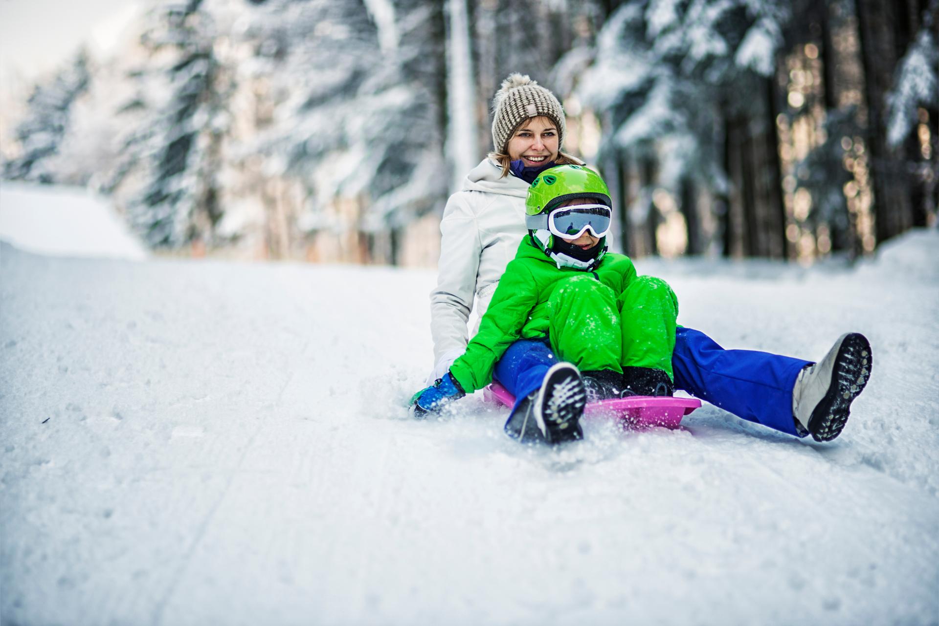 Family snow sledding in France ski resort
