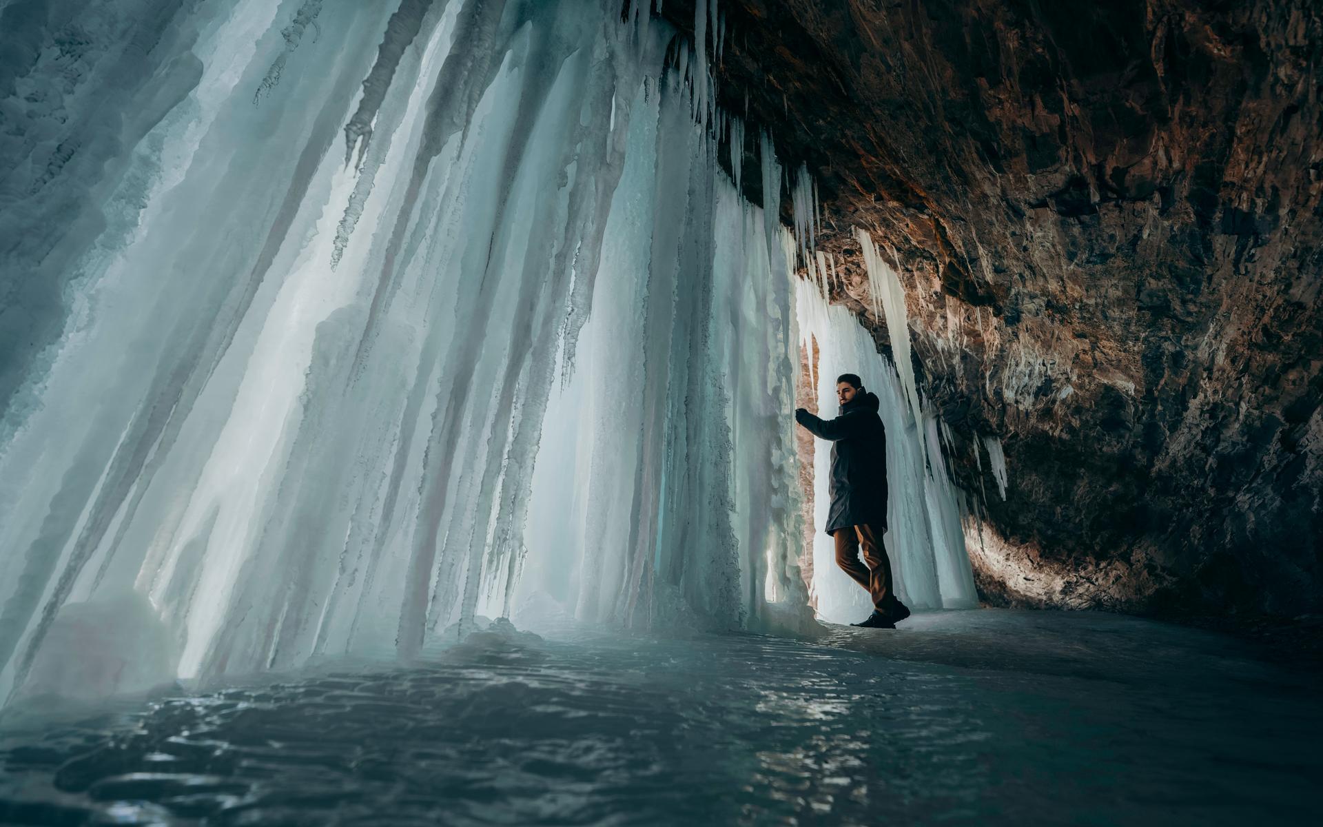 Tourist exploring glacier ice cave while on holiday